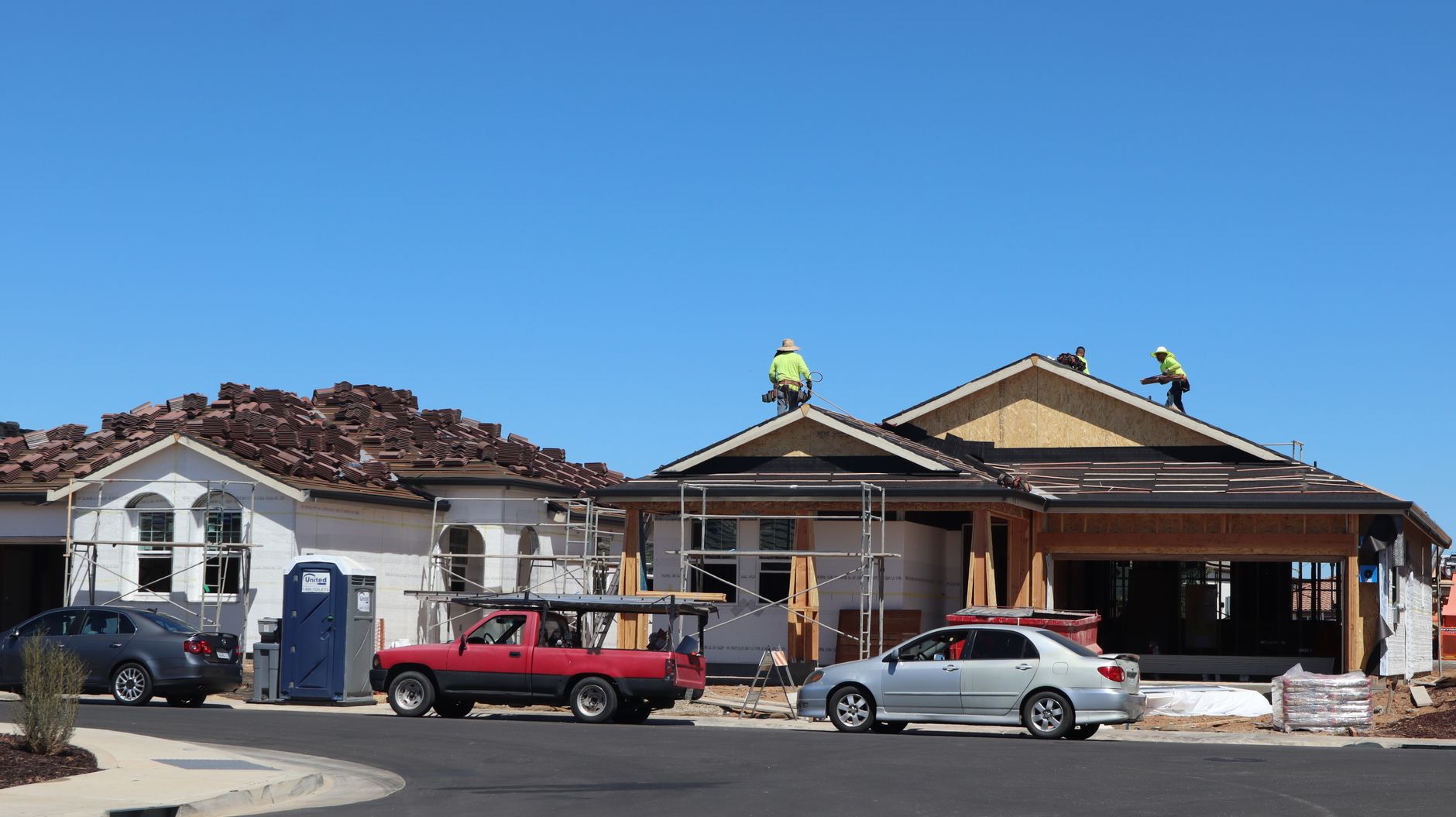 Roofers working on the roof of a new suburban home